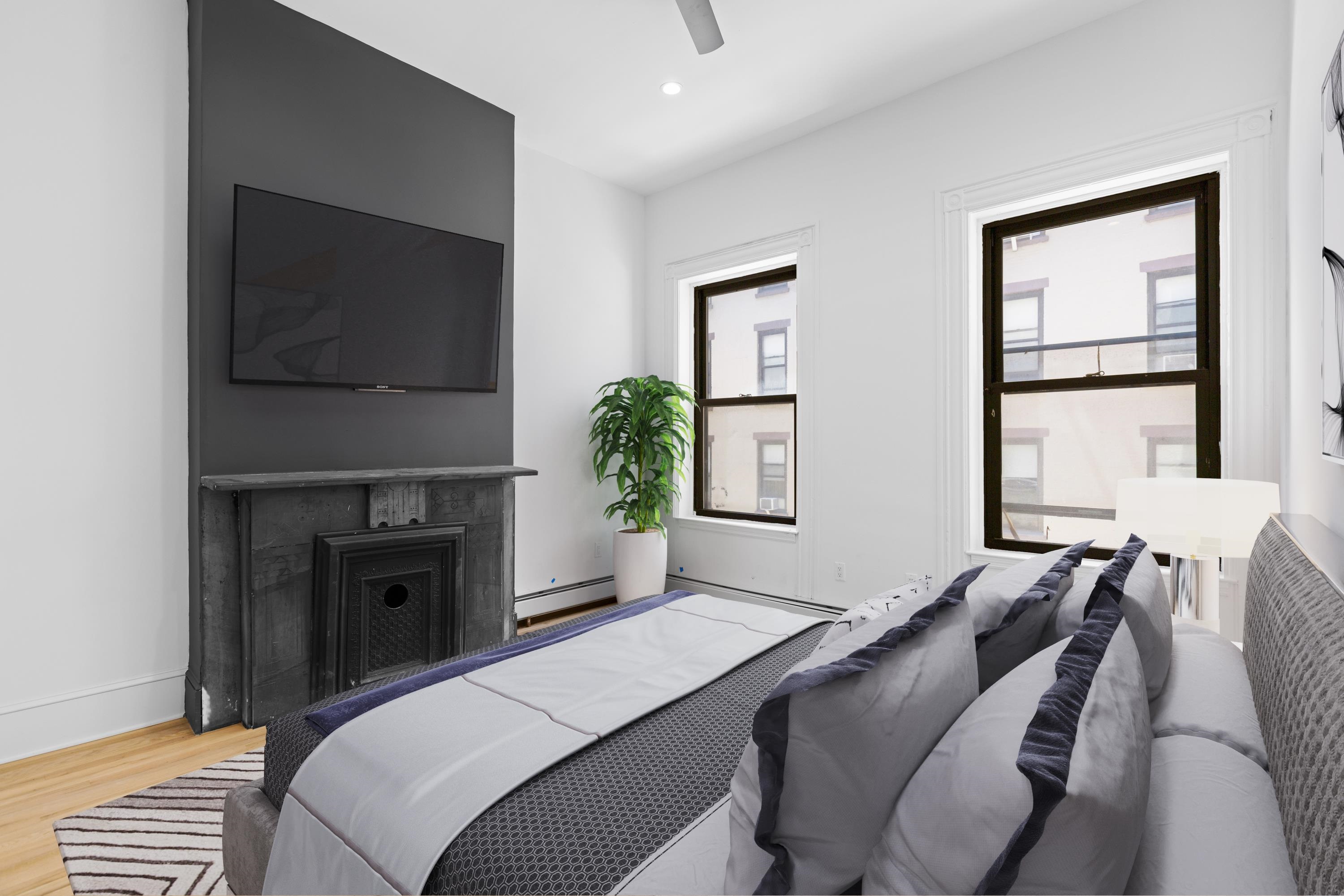 76 Washington Street, Unit 2 Hoboken, NJ 07030 - Photo 5 of 14 a bedroom with a bed and a television