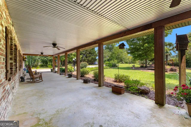a kitchen view with stainless steel appliances kitchen island granite countertop a refrigerator a stove a dining table and chairs with wooden floor