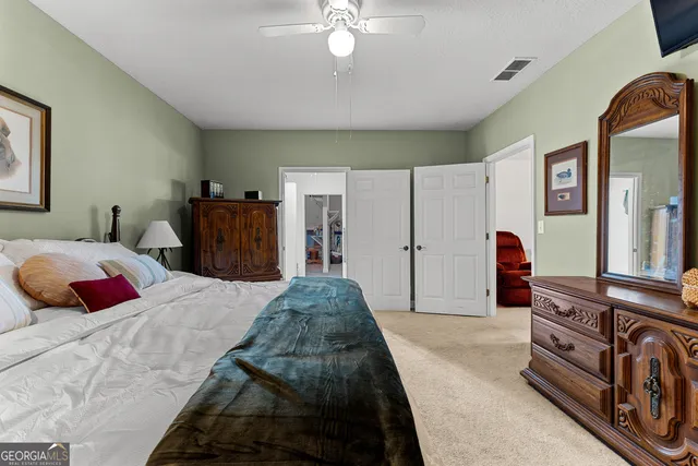 a bedroom with a large bed and a chandelier