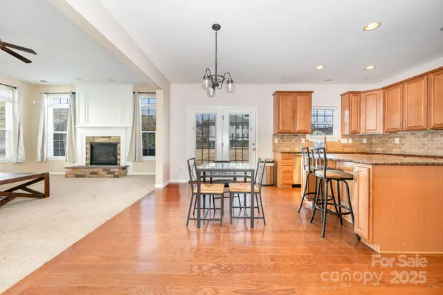 a living room with stainless steel appliances kitchen island granite countertop furniture and a fireplace
