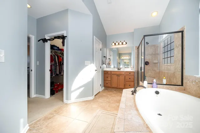 a bathroom with a tub a sink and mirror