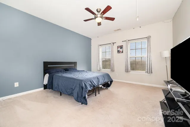 a spacious bedroom with a bed and a flat screen tv