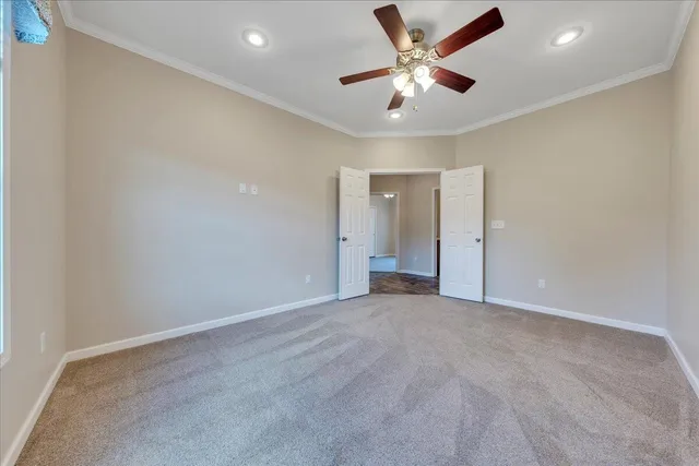 an empty room with windows and ceiling fan