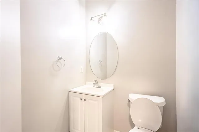 a bathroom with a toilet a sink and mirror