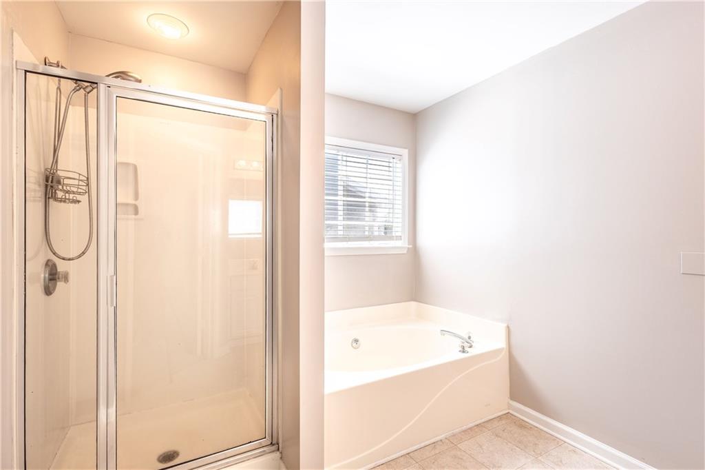1545 Anna Ruby Lane Kennesaw, GA 30152 - Photo 22 of 45 a bathroom with a bathtub and a shower