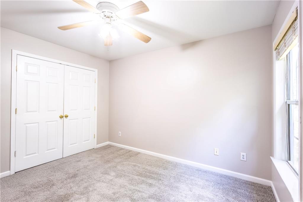 1545 Anna Ruby Lane Kennesaw, GA 30152 - Photo 35 of 45 an empty room with a chandelier fan and windows
