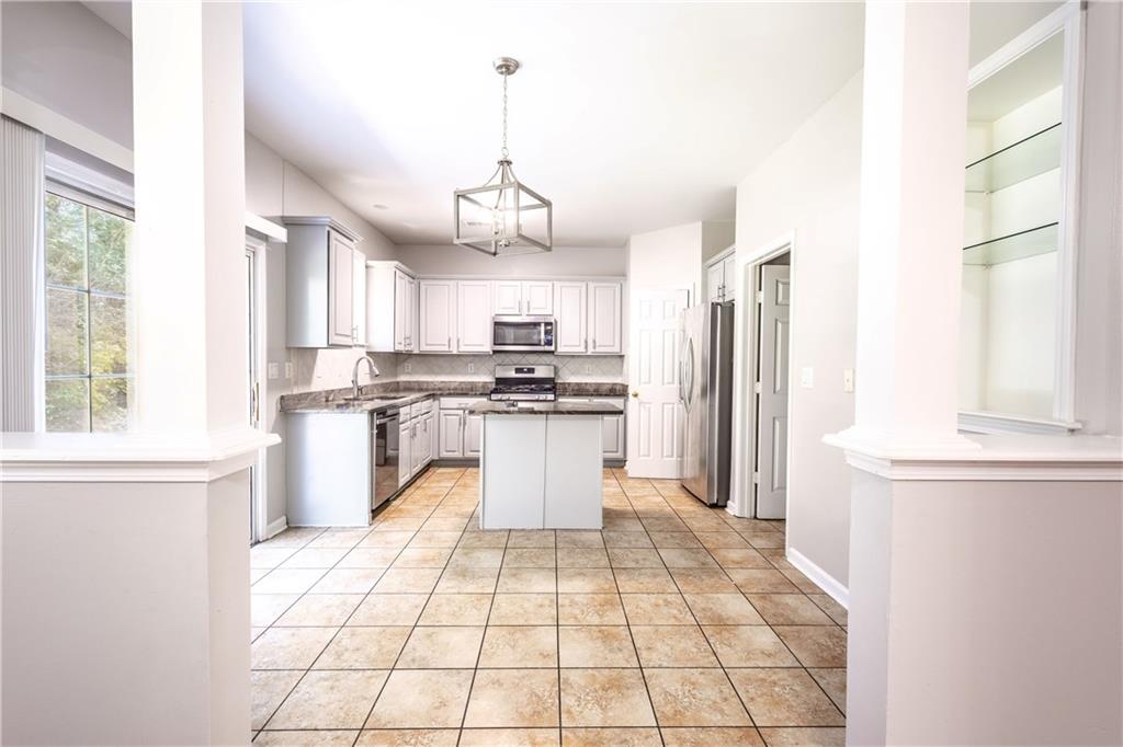 1545 Anna Ruby Lane Kennesaw, GA 30152 - Photo 8 of 45 a kitchen with stainless steel appliances kitchen island granite countertop a refrigerator a sink dishwasher a stove and white cabinets with wooden floor