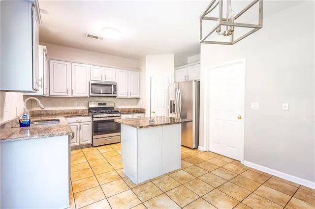 a kitchen with stainless steel appliances a refrigerator sink and microwave
