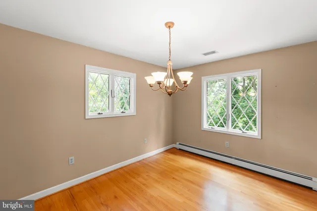 a view of a room with wooden floor and chandelier
