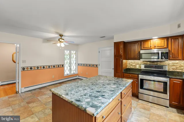 a view of kitchen with granite countertop cabinets and window