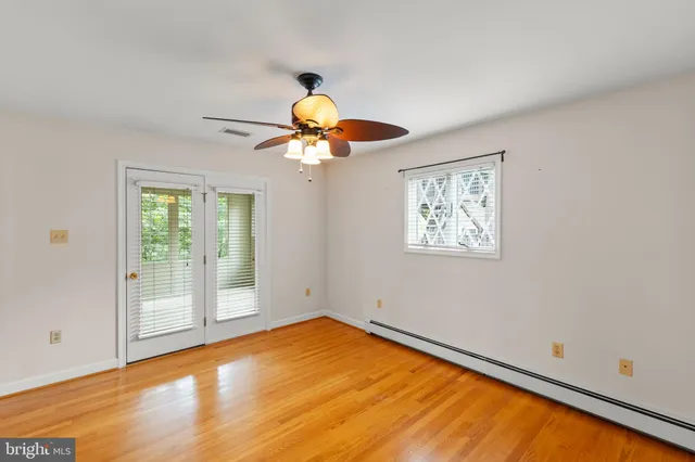 a view of empty room with wooden floor