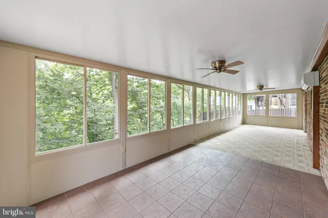 a view of a porch with a table and chairs and floor to ceiling window