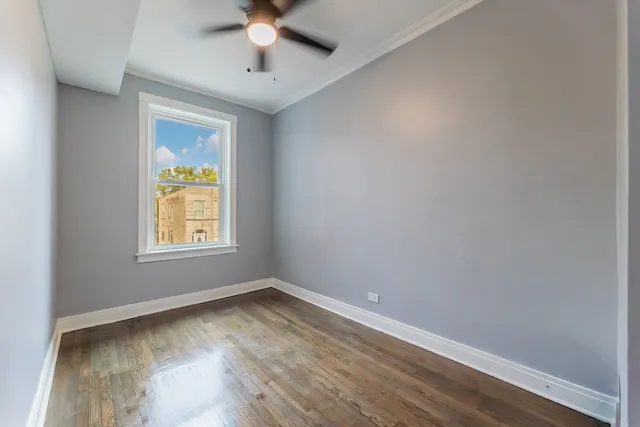 an empty room with a window and ceiling fan