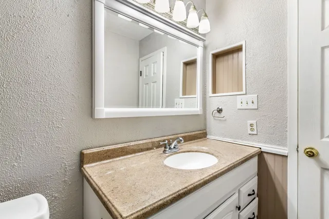 a bathroom with a granite countertop sink and a mirror