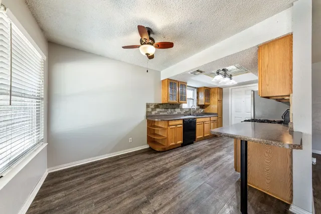 a kitchen with stainless steel appliances granite countertop a sink a stove and a wooden floors