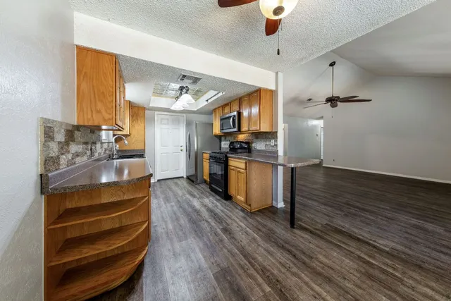 a kitchen with stainless steel appliances kitchen island granite countertop a stove and a refrigerator