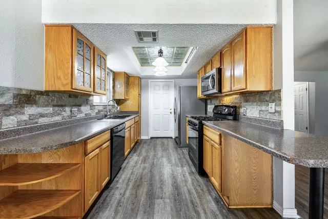 a kitchen with stainless steel appliances granite countertop a stove a sink and a refrigerator