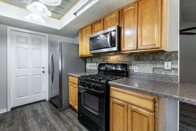 a kitchen with stainless steel appliances granite countertop a stove and a microwave