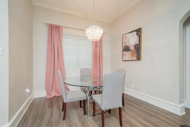 a view of a dining room with furniture wooden floor and a chandelier