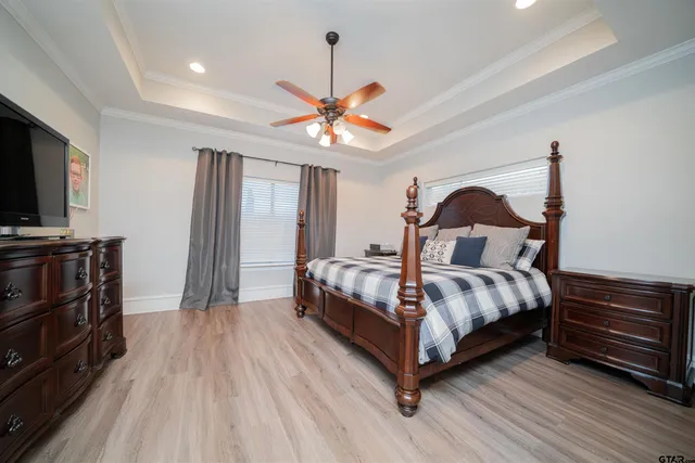 a bedroom with a bed and a flat tv screen on dresser