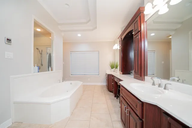 a spacious bathroom with a bathtub sink and mirror