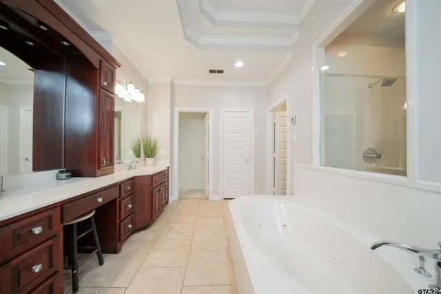 a spacious bathroom with a tub sink and mirror
