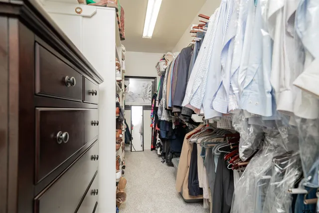 a view of walk in closet with clothes and shoes