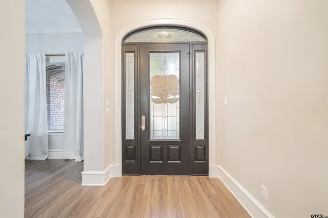 a view of a hallway with wooden floor and a dining room