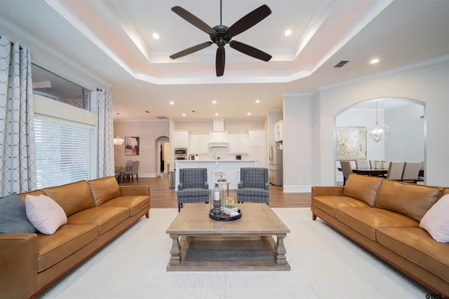 a living room with furniture kitchen view and a chandelier