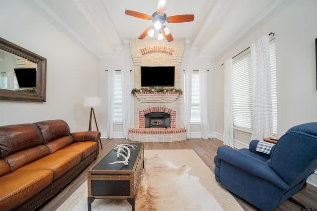 a living room with furniture a flat screen tv and a fireplace