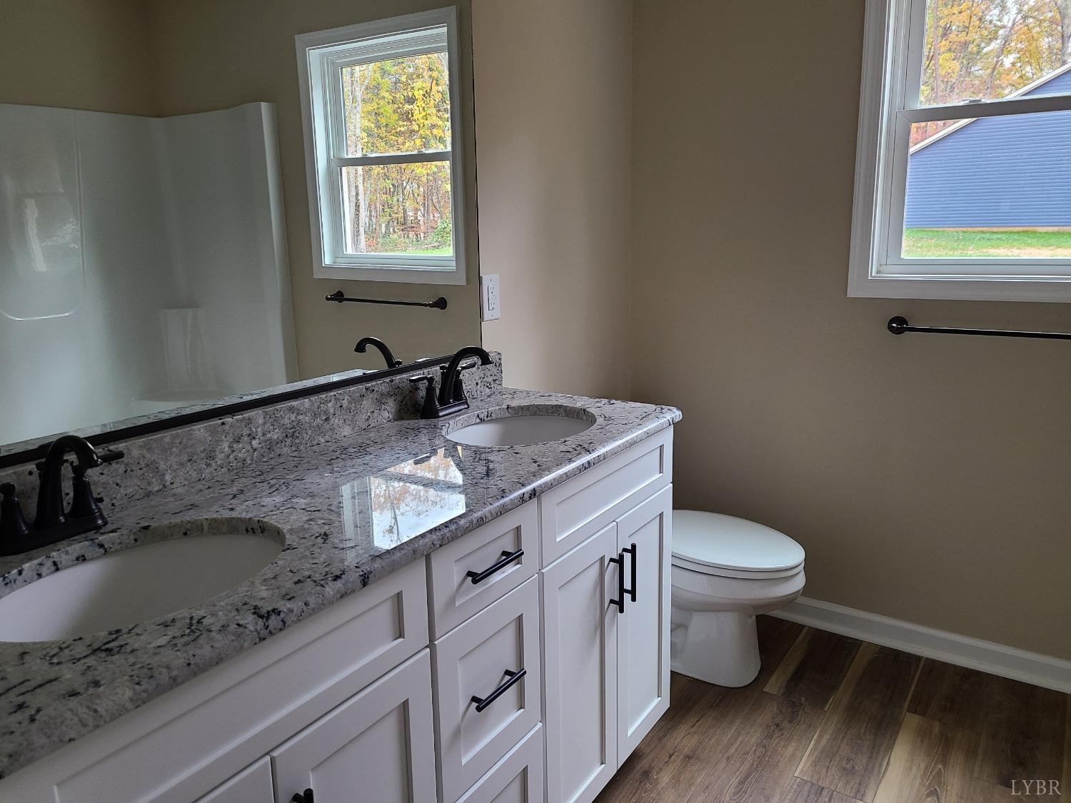 2375 Stonewall Road Concord, VA 24538 - Photo 12 of 13 a bathroom with a granite countertop toilet a sink and a mirror