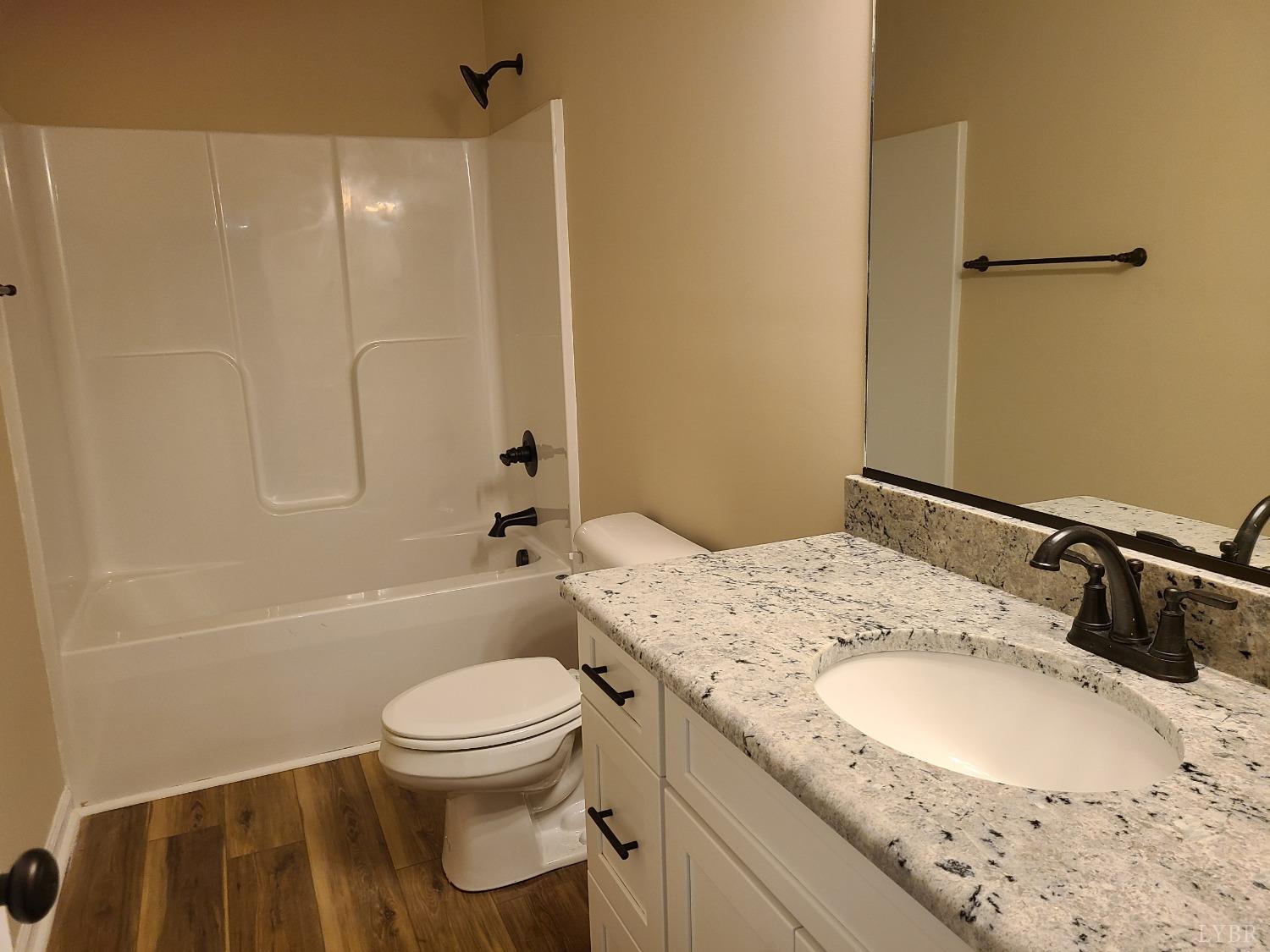 2375 Stonewall Road Concord, VA 24538 - Photo 13 of 13 a bathroom with a granite countertop sink toilet and shower