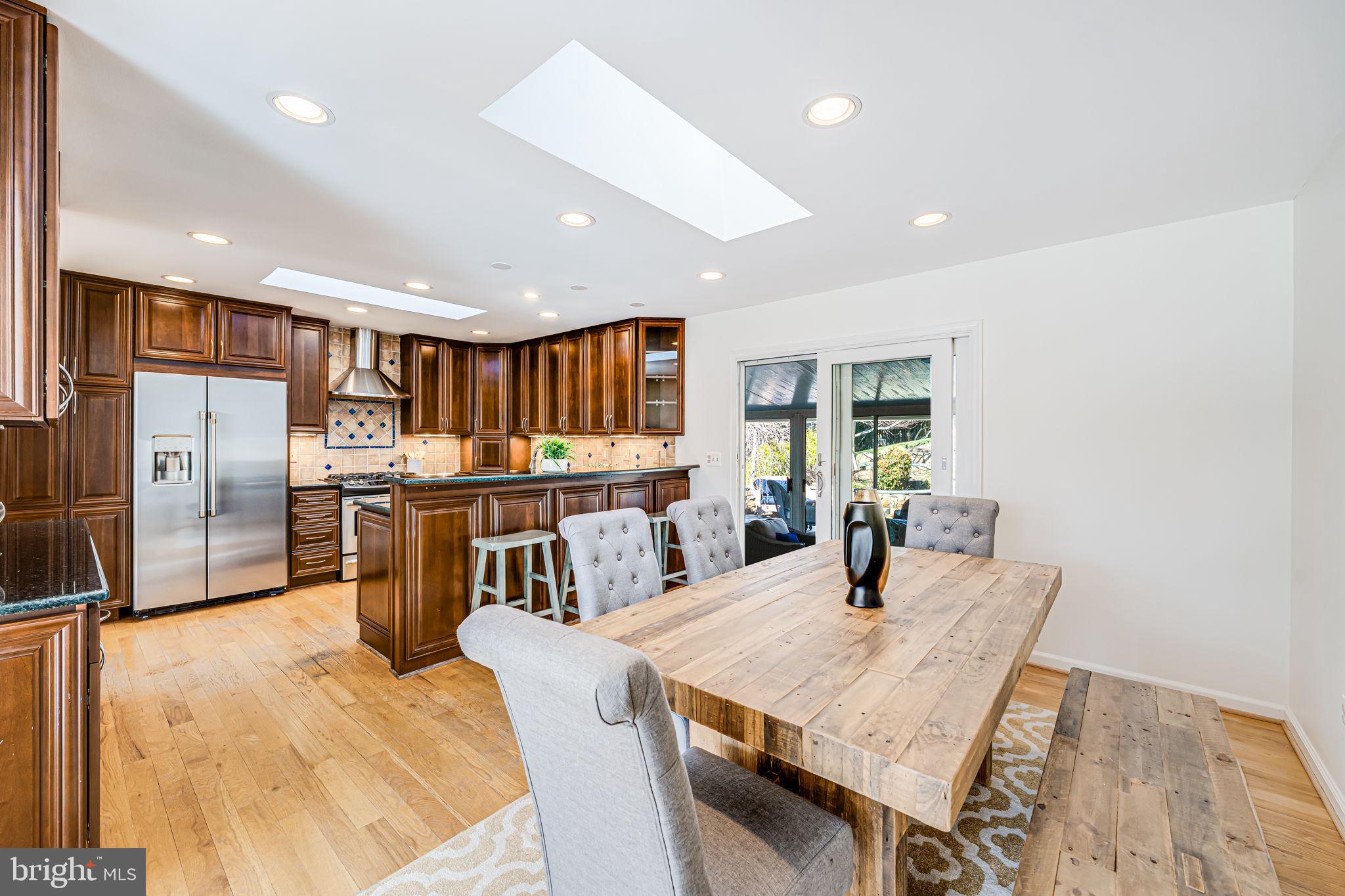 1831 Quartet Circle Vienna, VA 22182 - Photo 11 of 60 a kitchen with stainless steel appliances kitchen island granite countertop a refrigerator a stove a sink dishwasher with a dining table and chairs