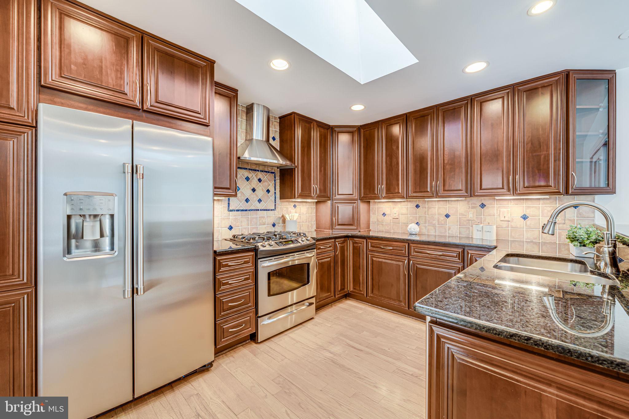1831 Quartet Circle Vienna, VA 22182 - Photo 15 of 60 a kitchen with granite countertop stainless steel appliances cabinets a sink and a counter space