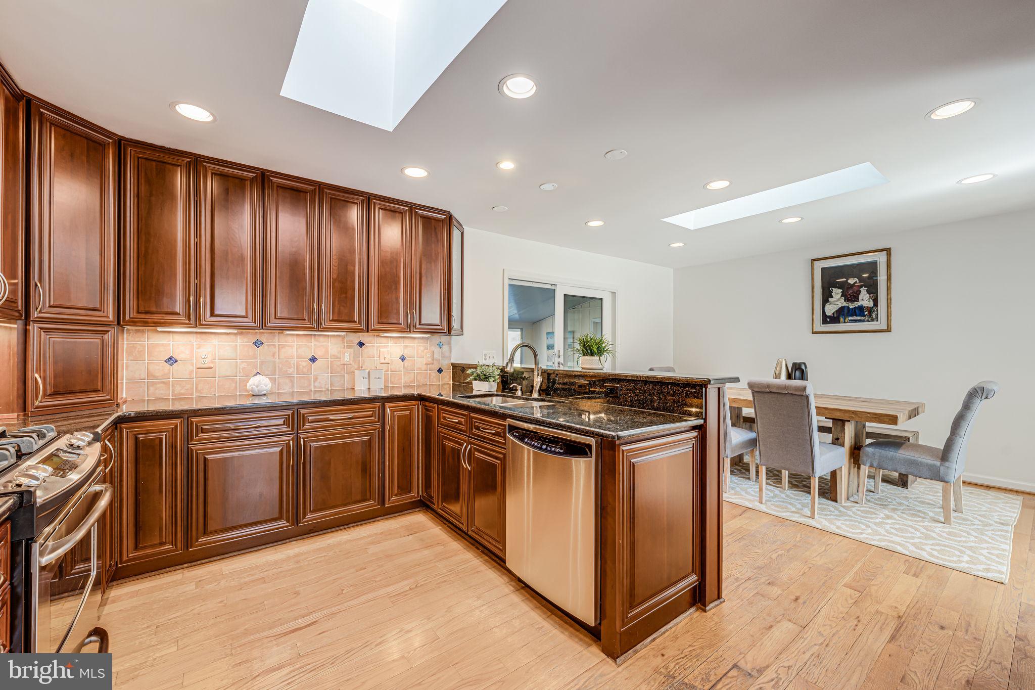 1831 Quartet Circle Vienna, VA 22182 - Photo 16 of 60 a kitchen with stainless steel appliances granite countertop wooden cabinets a stove top oven a sink and dishwasher