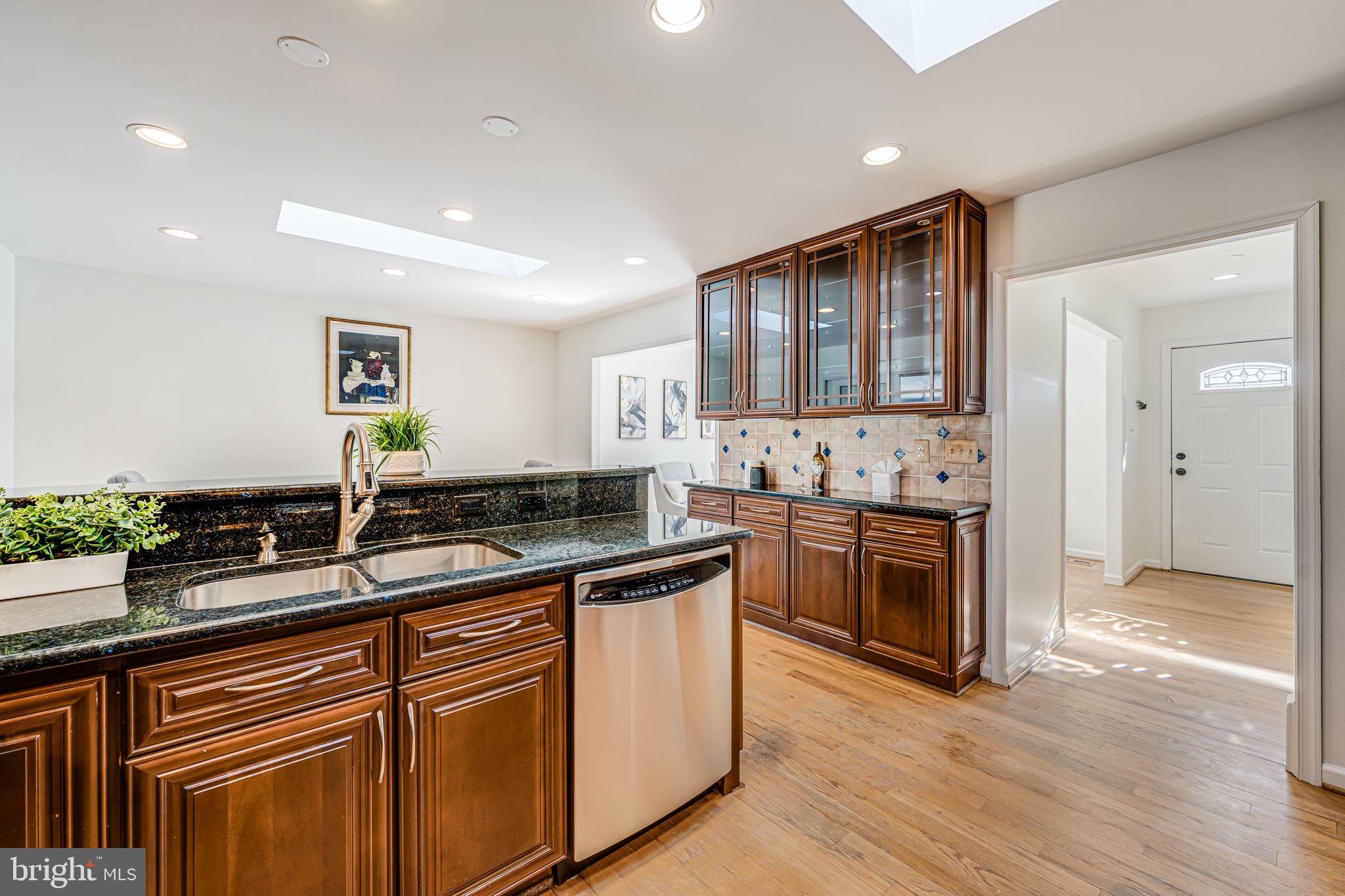 1831 Quartet Circle Vienna, VA 22182 - Photo 18 of 60 a kitchen with stainless steel appliances granite countertop a sink stove and wooden cabinets