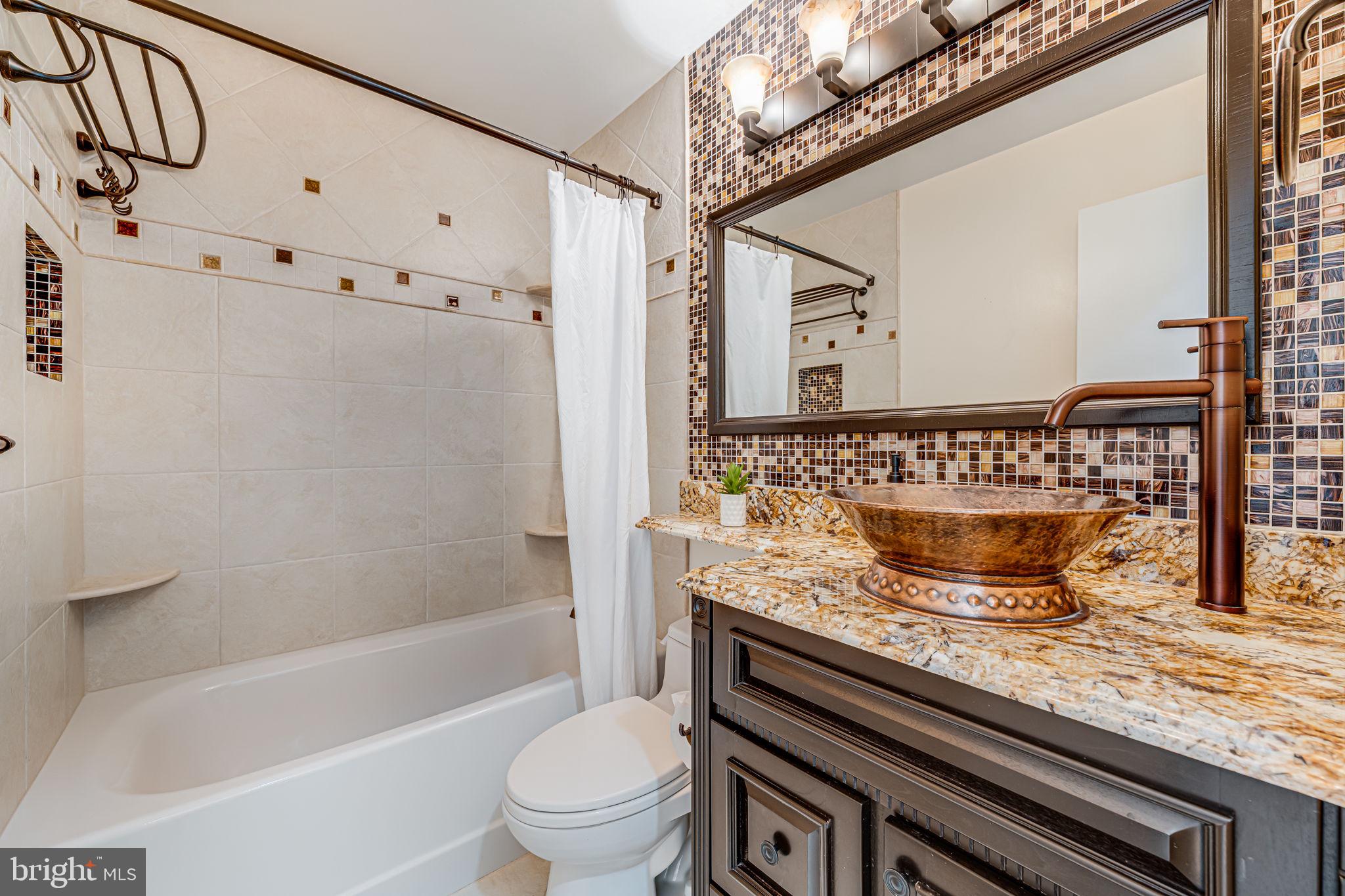1831 Quartet Circle Vienna, VA 22182 - Photo 33 of 60 a bathroom with a granite countertop sink a toilet and shower