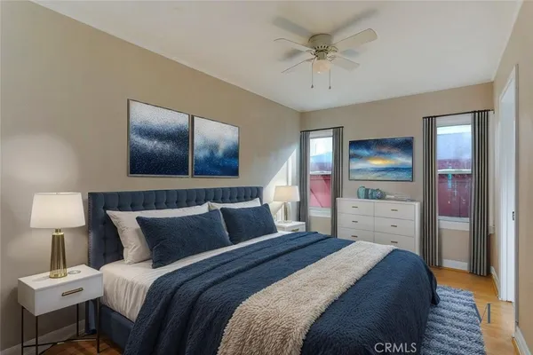 a bedroom with a bed and a lamp on a dresser