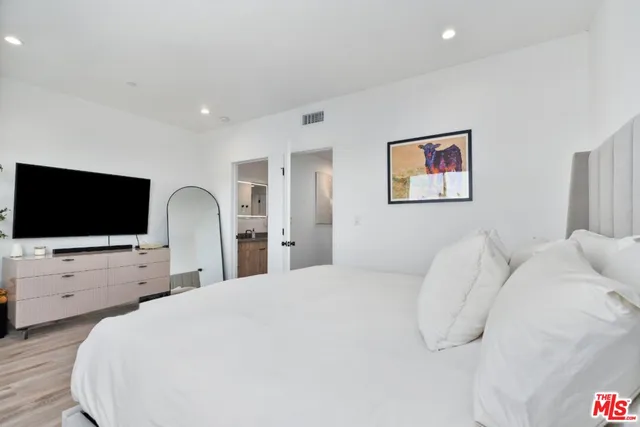 a bedroom with a bed and a flat screen tv