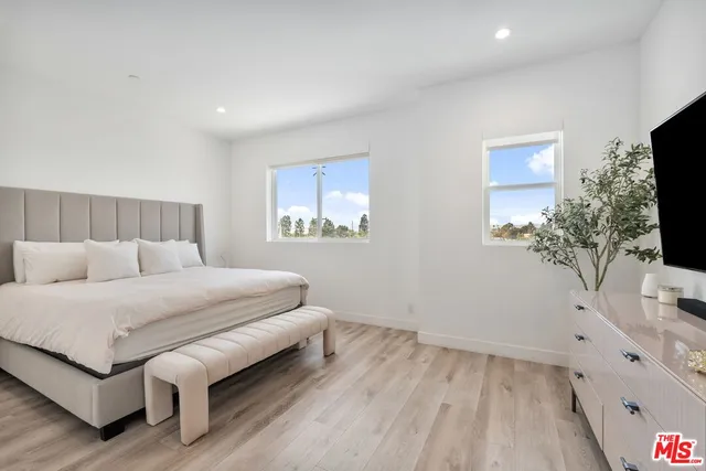 a bedroom with a bed and a flat screen tv