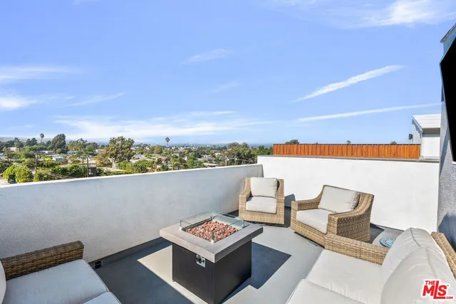 a terrace with outdoor seating and trees