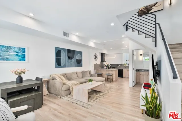 a living room with furniture and kitchen view