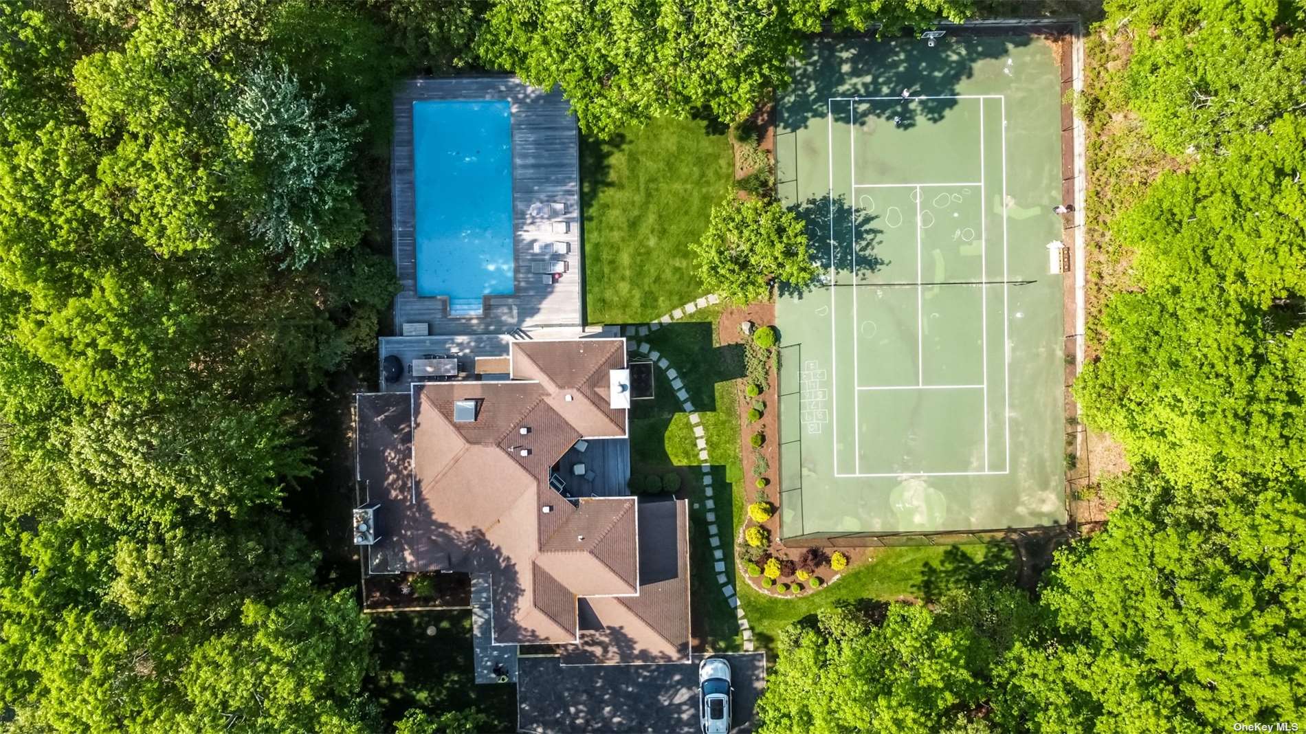 aerial view of a house with a yard and large trees