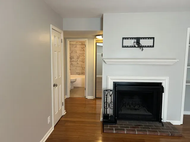 a living room with a fireplace and a ceiling fan