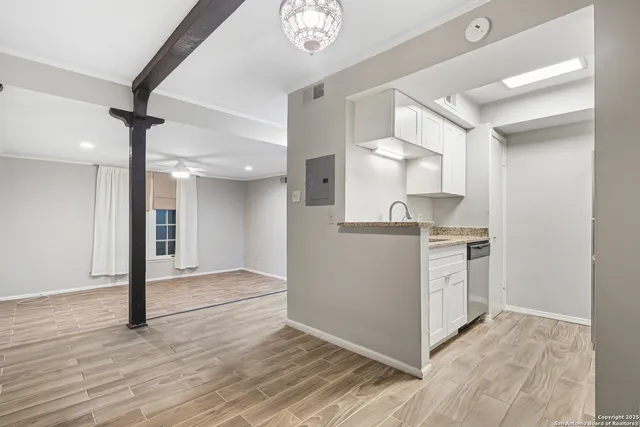 a view of kitchen with granite countertop cabinets and refrigerator