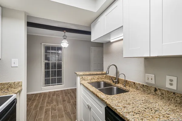 a kitchen with granite countertop a sink and a stove