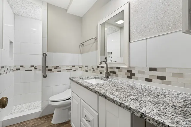 a bathroom with a granite countertop sink and a mirror