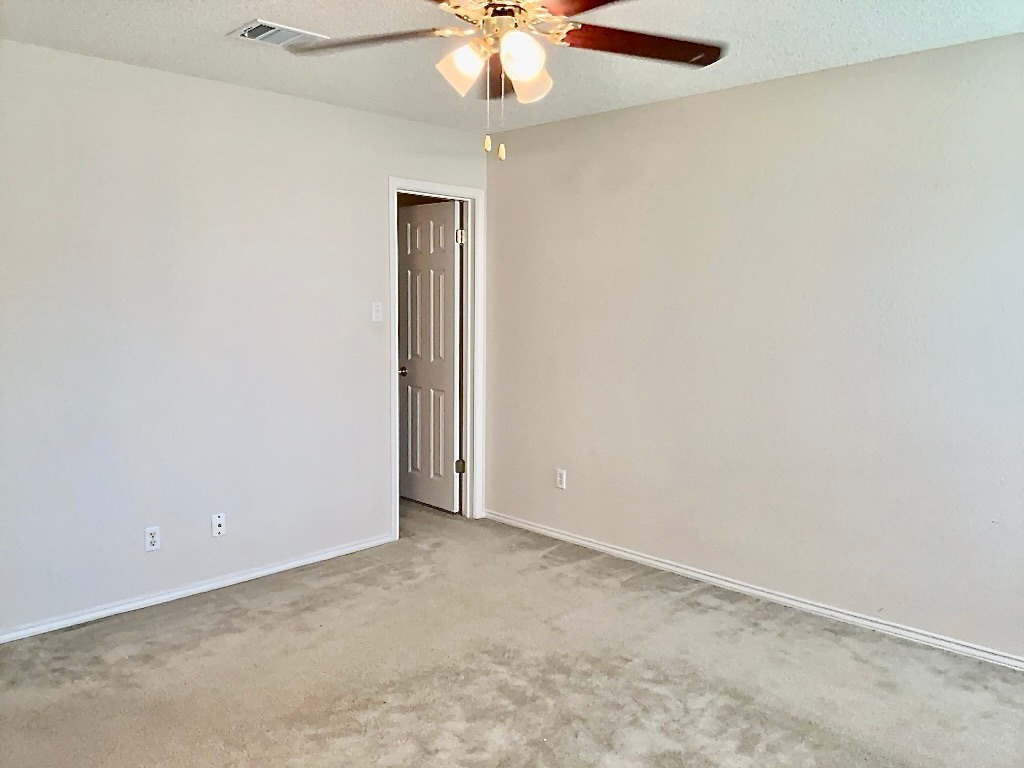 1313 Terra Street Round Rock, TX 78665 - Photo 13 of 25 an empty room with a chandelier fan and a chandelier fan