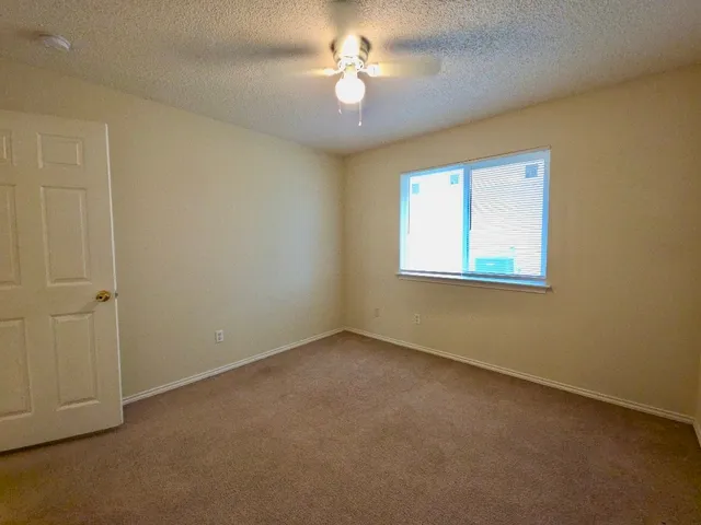 an empty room with closet and a ceiling fan