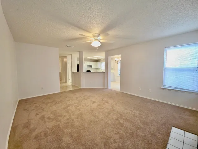 a view of a big room with windows and chandelier fan